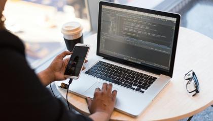 Person sitting at a laptop displaying code