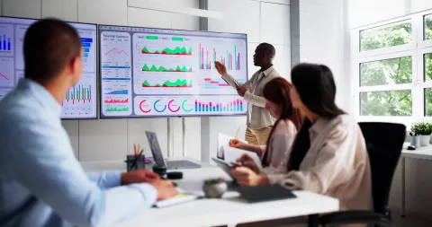 People Looking at graphs on a computer screen in a room.