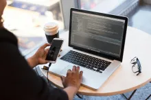 Person sitting at a laptop displaying code